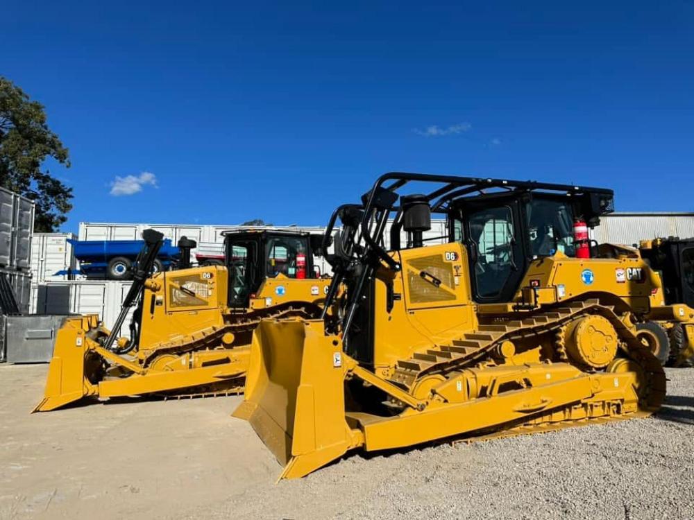 Two skid steers in a yard