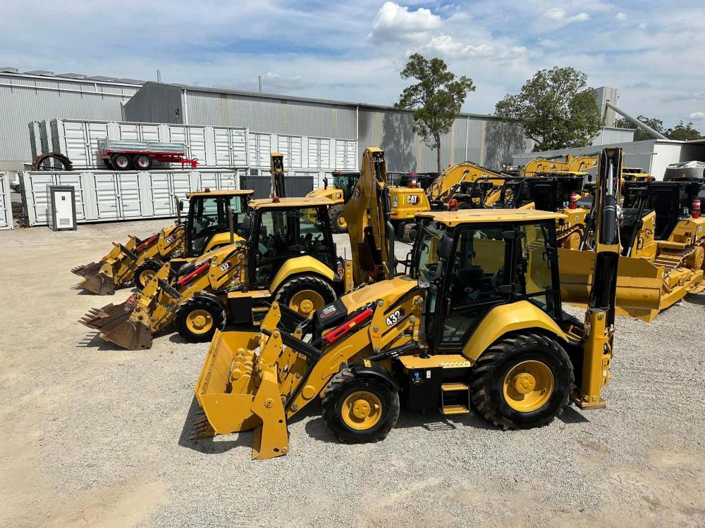 Some yellow backhoe loaders