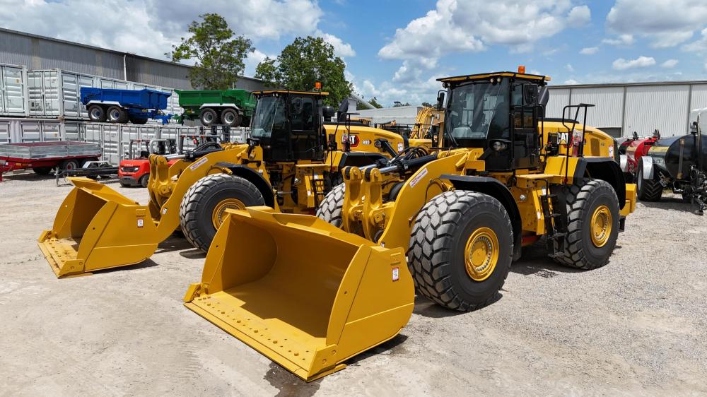 Some yellow loaders in a yard