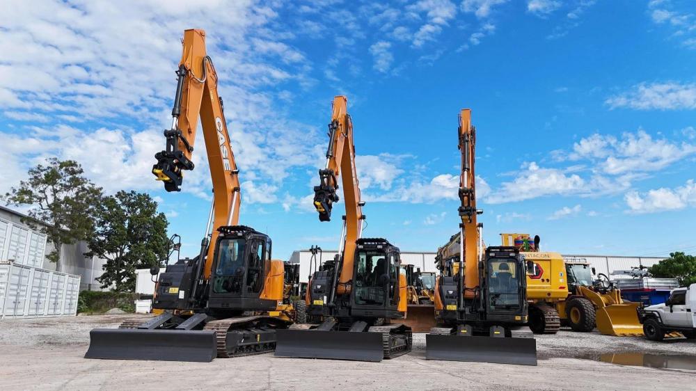 3 yellow excavators in a yard