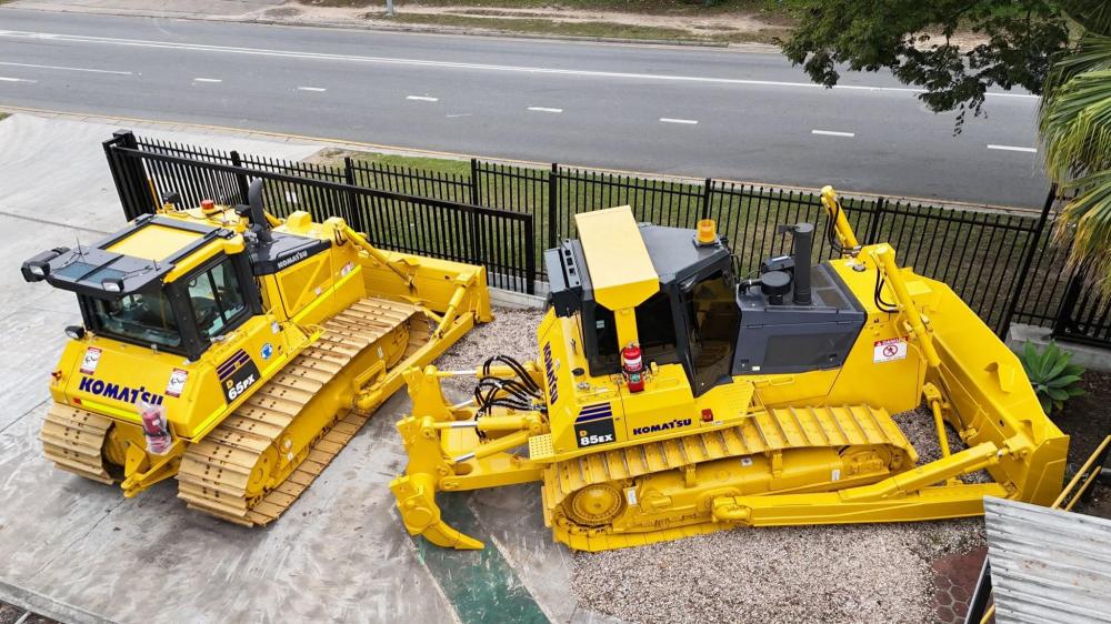 Two yellow machines by the side of a road